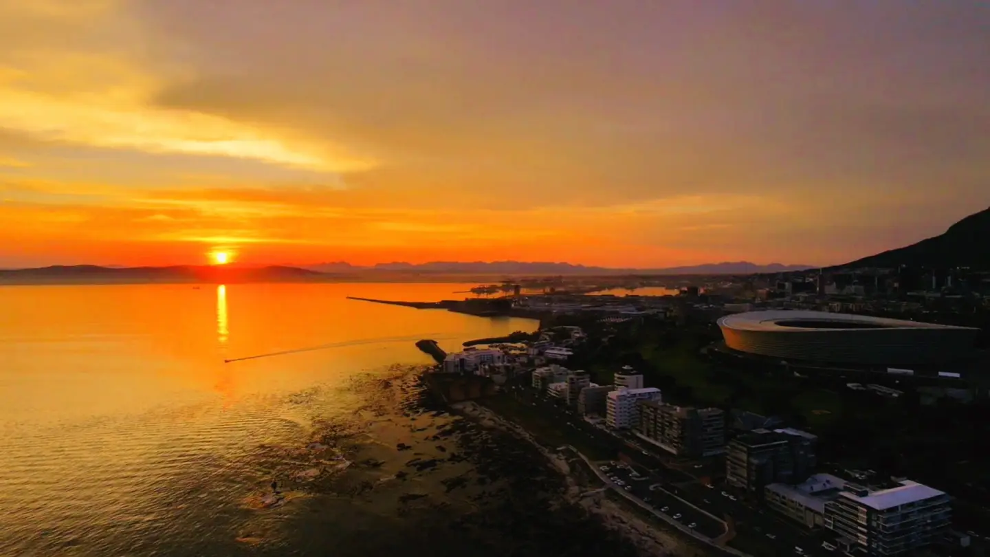 Aerial city sunset over a coastal stadium